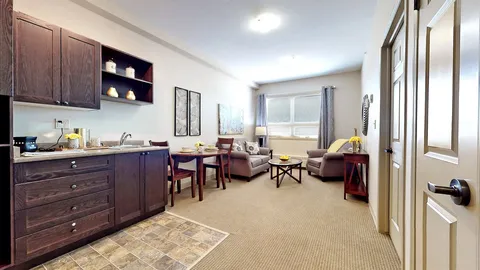 Kitchenette and sitting area with armchairs beside windows
