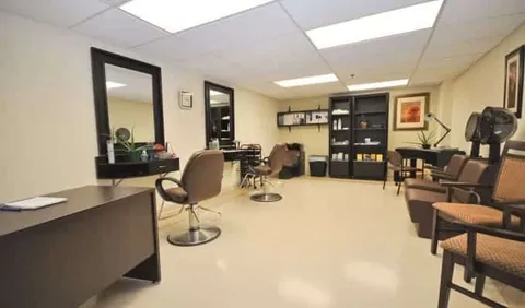 Salon with styling chairs, mirrors, product shelves and hooded dryers
