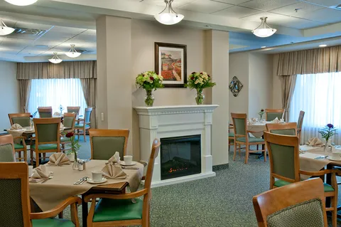 Dining room with set tables around a central fireplace.