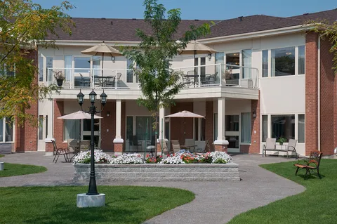 Residence balconies and covered patio beside a landscaped lawn.