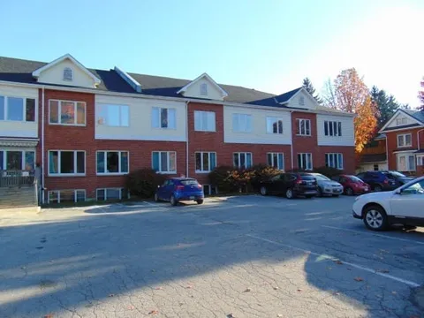 Residence exterior with red brick, light siding and parked cars