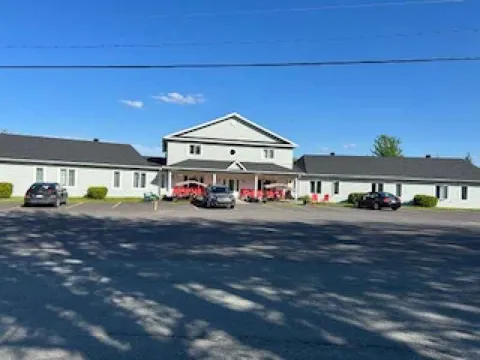 Residence building with a central entrance, covered porch and parking area