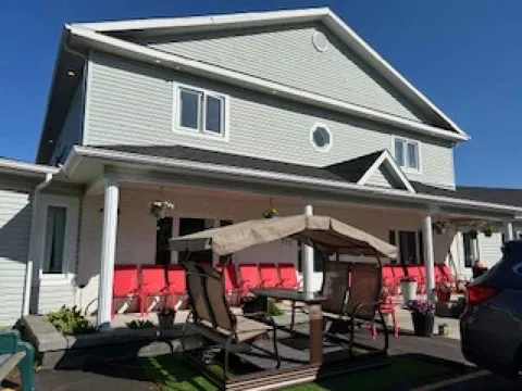 Residence porch with red chairs, flower pots and a covered bench swing