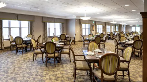 Dining room with set tables, striped chairs and windows