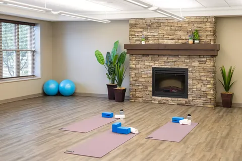 Exercise room with yoga mats, exercise balls and a stone fireplace