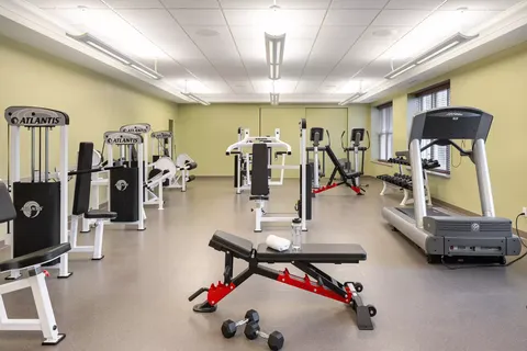Fitness room with weight machines, a treadmill and a bench