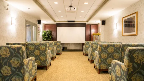 Theatre seating arranged in front of a projection screen.