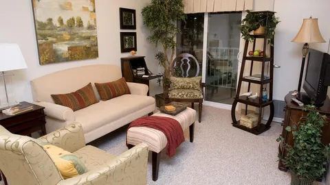 Suite living room with a sofa, armchairs and television.