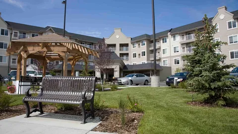 Residence exterior behind a courtyard bench and pergola.