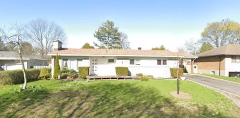 Single-storey residence with a front lawn and paved drive.