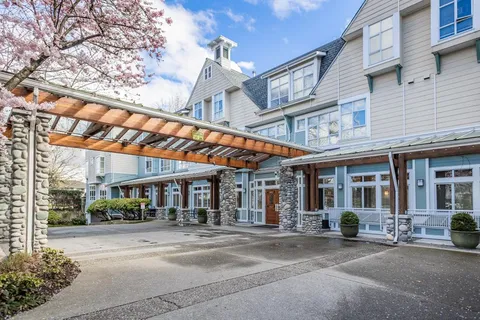 Residence entrance with a pergola and flower beds