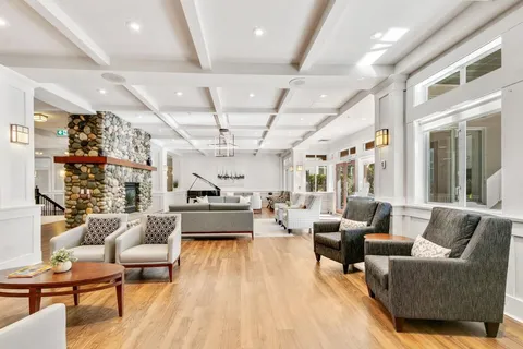 Lounge with armchairs, a stone fireplace and potted plants