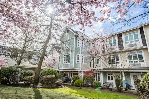 Residence facade beside flowering trees and landscaped gardens
