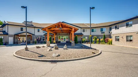 Residence wing and entrance canopy beside a circular drive.
