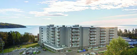 Residence building viewed from above with balconies and parking.