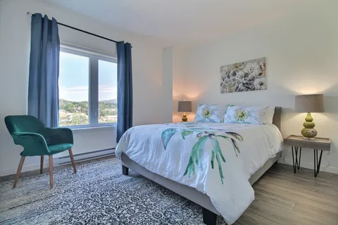 Bedroom with a double bed, bedside lamps and a window.