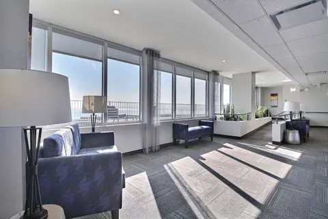 Window-side sitting area with blue armchairs.