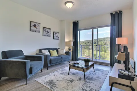 Suite living room with blue seating and a patio door.