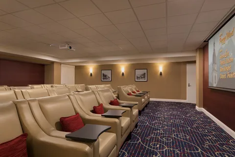 Theatre with rows of reclining seats facing a screen.