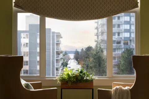 Seating alcove beside a large window overlooking the neighbourhood.