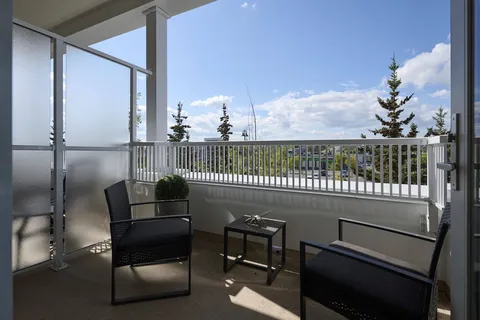 Balcony with two chairs, a small table and a metal railing
