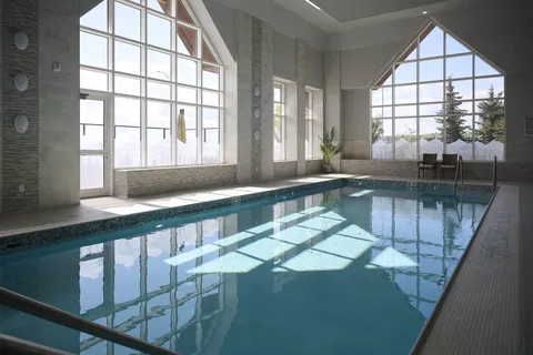 Indoor swimming pool with a handrail and large windows