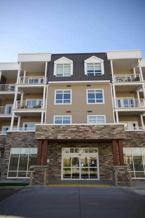 Tall building facade with windows, stone columns and an entrance canopy
