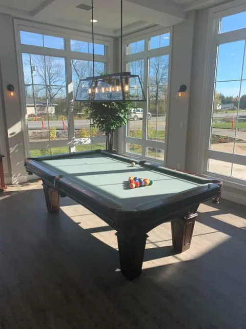 Billiards table beside tall windows