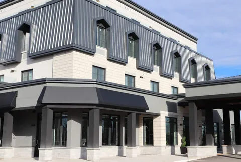 Residence facade and covered entrance beneath metal clad upper floors