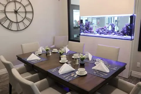 Private dining table beside a built in aquarium