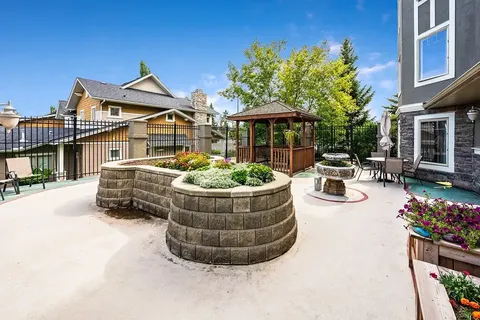 Garden patio with raised flower beds, gazebo, fountain and outdoor chairs