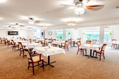 Dining tables and wooden chairs beside windows