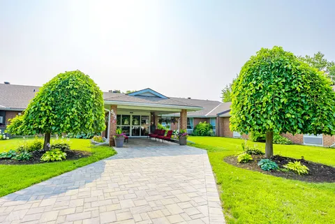 Low-rise brick residence with a covered entrance and landscaped walkway