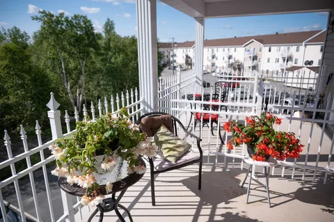 Balcony with a small table, chairs and potted flowers
