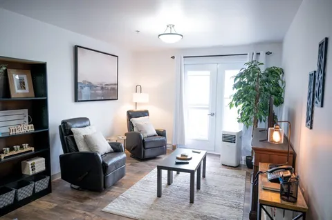 Sitting area with two recliners, a coffee table and a balcony door