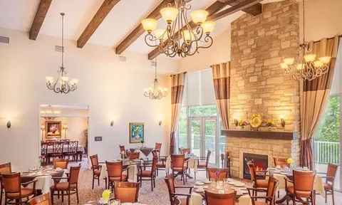 Dining room with stone fireplace and exposed ceiling beams