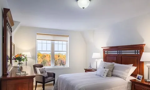 Bedroom with wood headboard, window and dressing table