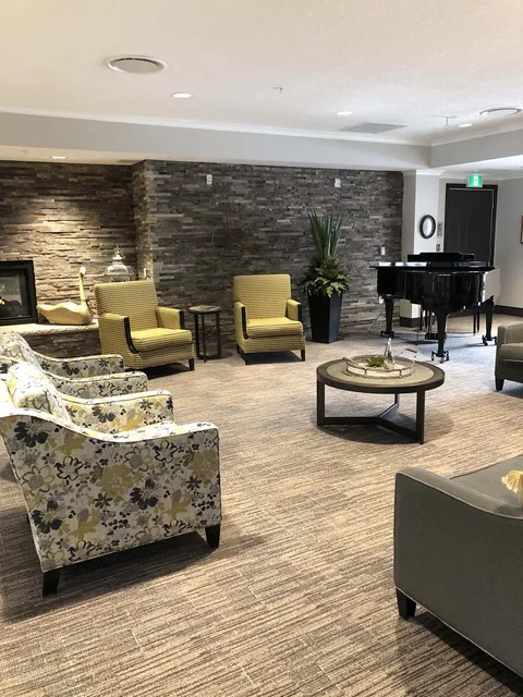 Lounge with upholstered seating, piano and coffee table.