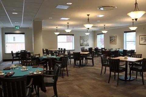 Dining room with tables, chairs and large windows.