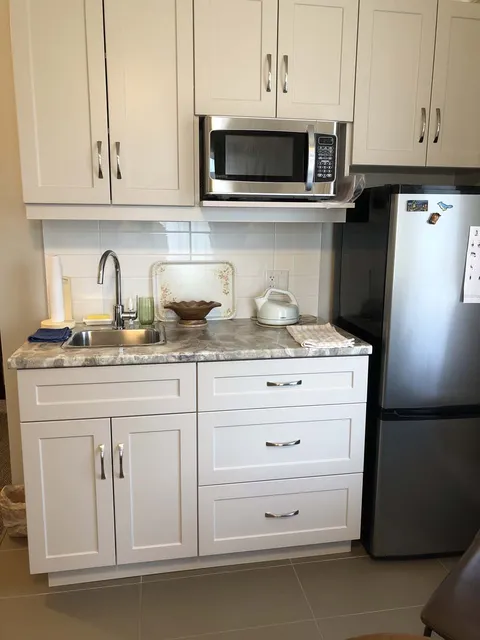 Suite kitchenette with refrigerator, microwave and sink.