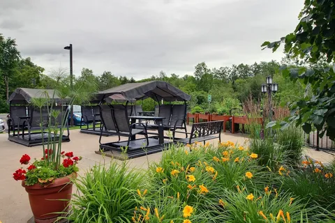 Patio with covered swings and planted flower beds