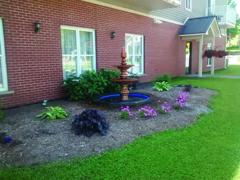 Flower bed and small fountain beside the building.