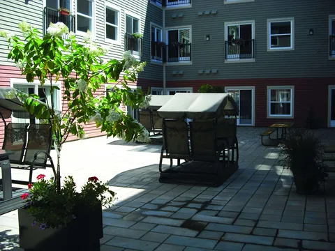 Paved courtyard with outdoor seating beside the residence.