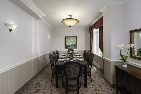 Long dining table with set places beside a window