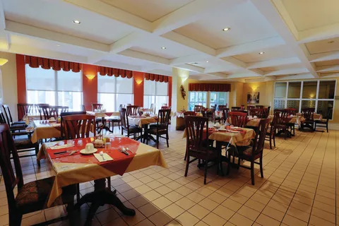 Dining room with set tables, wooden chairs and large windows