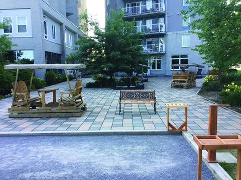 Courtyard with tiled paths, benches and garden swings.
