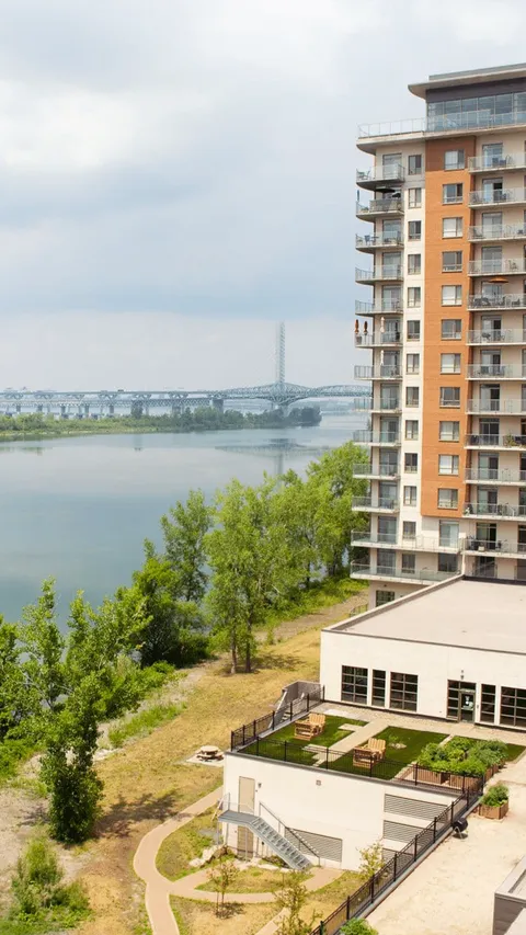 Residence beside a river with balconies, a terrace and garden beds