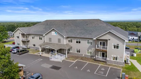 Two-storey residence with a covered entrance, balconies and a parking area