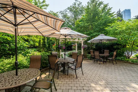 Paved garden terrace with umbrella tables and chairs