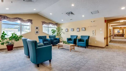 Lounge with blue armchairs and large windows.